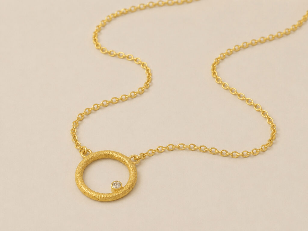 goldene Halskette mit rundem Anhänger und Diamant