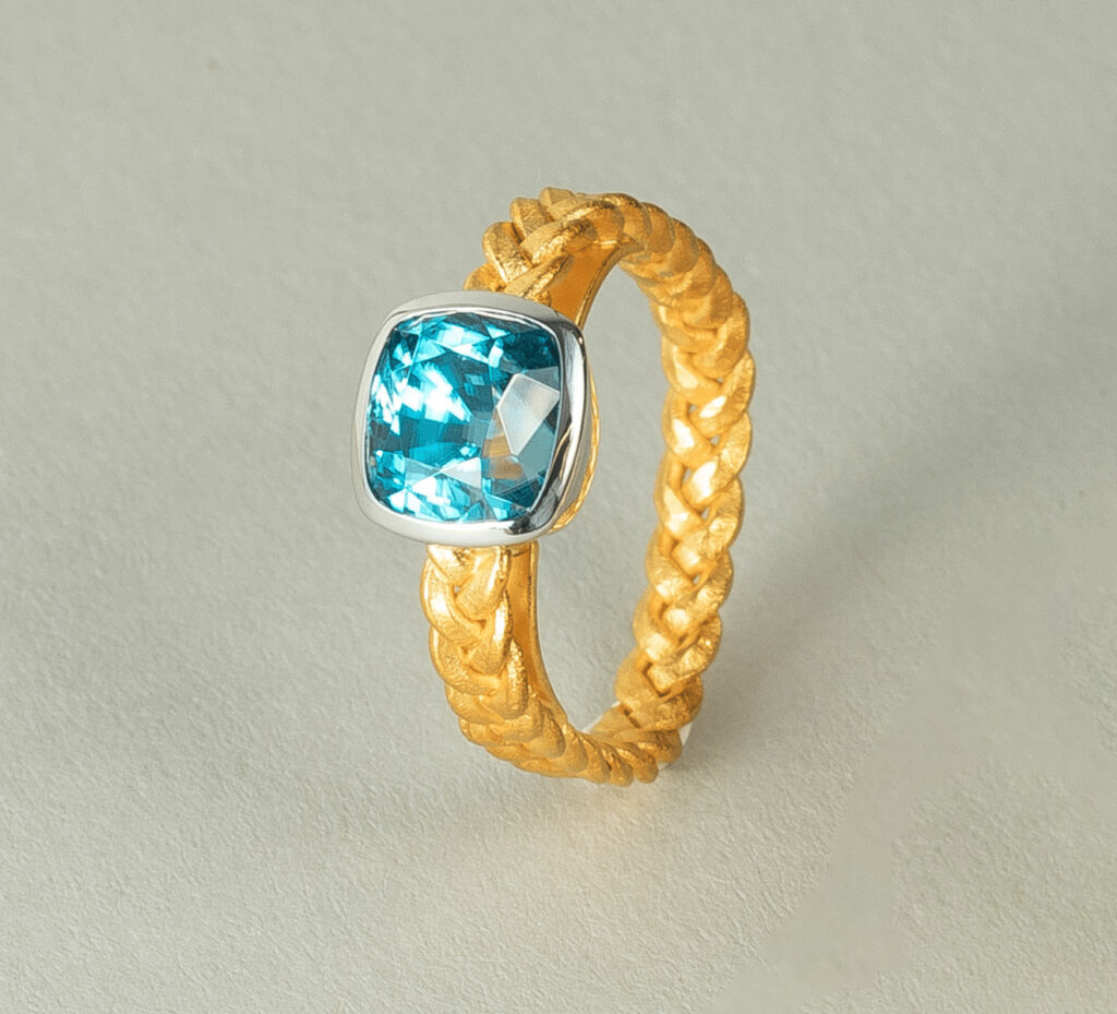geflochtener Goldring mit blauem Diamant
