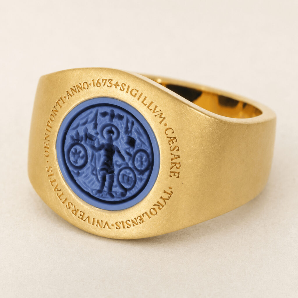 goldener Siegelring mit blauem Siegel und Gravur