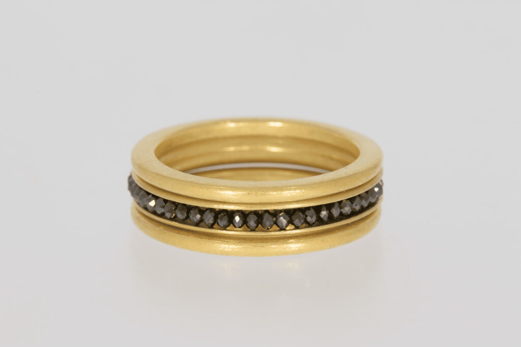 Goldring versehen mit schwarzen Edelsteinen