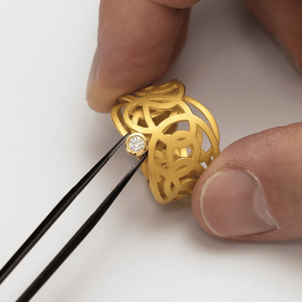 Goldring mit rundem Diamant bei der Fertigung