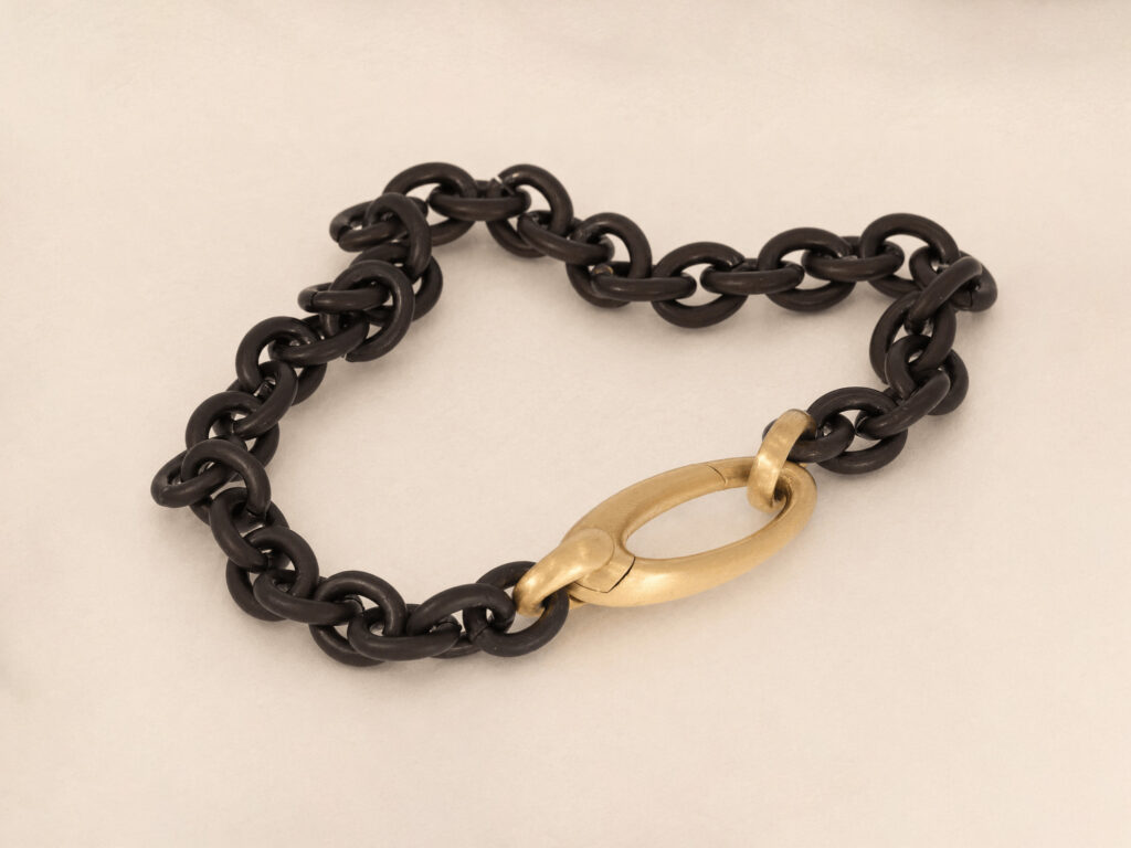 schwarzes Armband mit goldenem Verschluss
