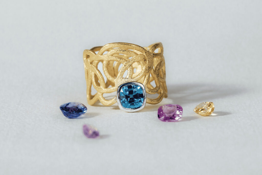 Goldring mit Muster und blauem Diamant