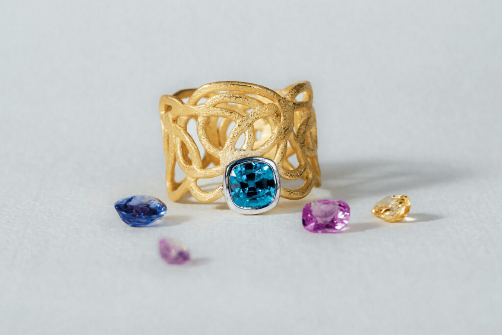Goldring mit Muster und blauem Diamant