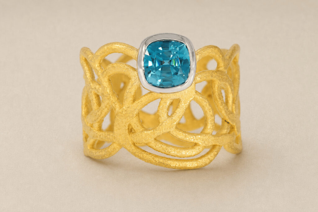 Goldring mit Muster und blauem Diamant
